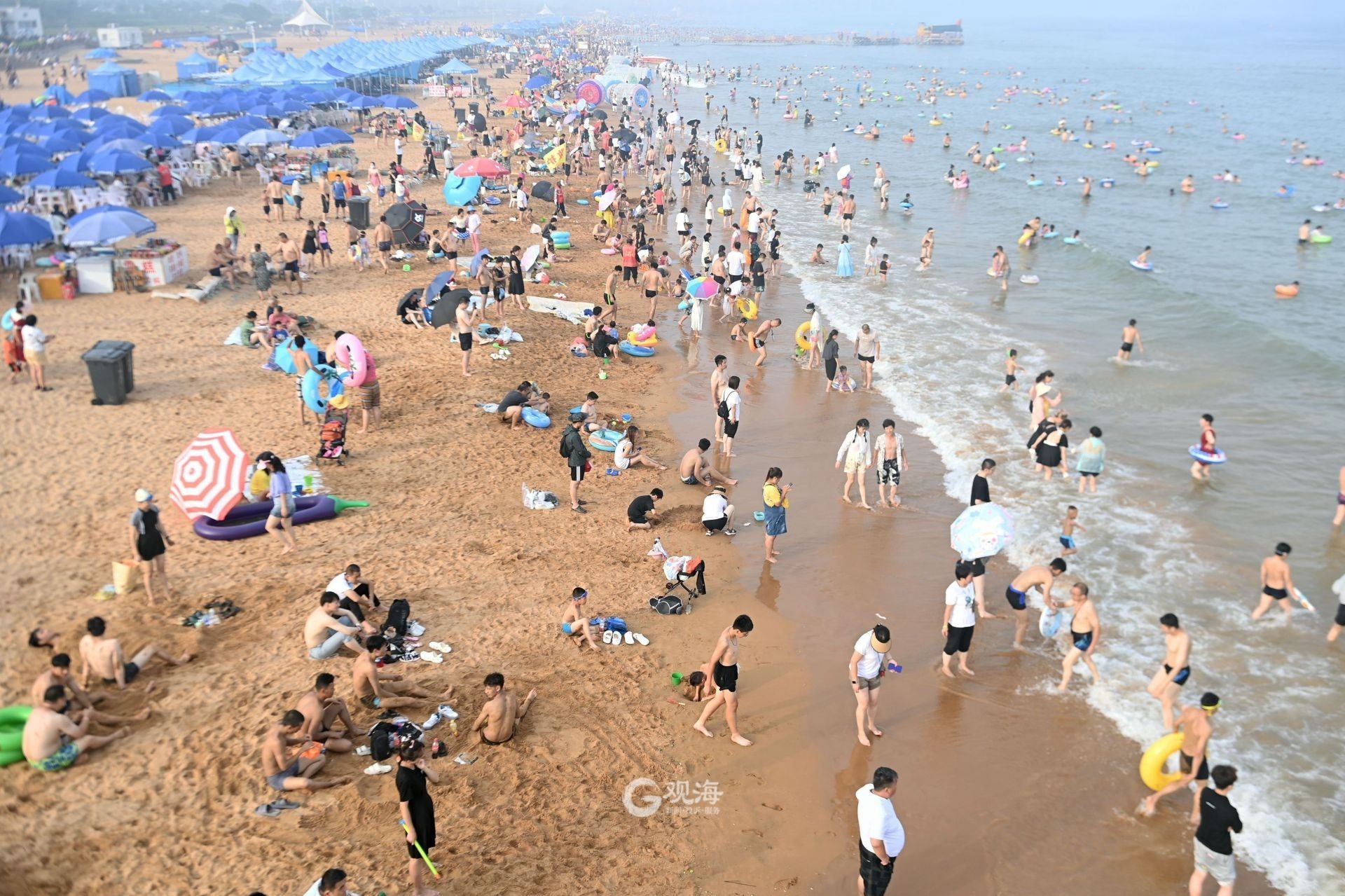 青岛西海岸新区金沙滩海水浴场迎来众多游客,在大海中享受清凉
