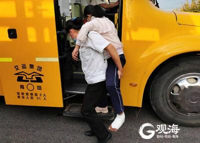 青岛校园里有道温馨风景：学生脚伤行走不便，校车照管员背着上下学