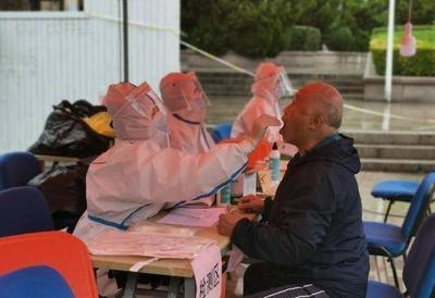 雨中即景：附近单位给检测点及时送来雨棚，社区干部们“扫楼”通知