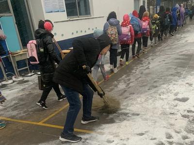 美丽校园披银装 党员教师扫雪忙