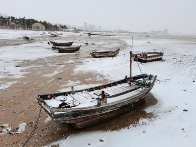 雪落渔船连成片 别有一番景象