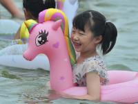 一浴实拍：数万人海边“下饺子” 萌娃抢镜