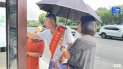 汽车东站附近，汗透工装的驾驶员被乘客悄悄撑伞遮阳……