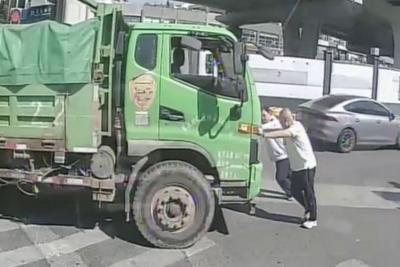 青岛街头货车抛锚堵路，公交驾驶员与乘客合力推车保畅通